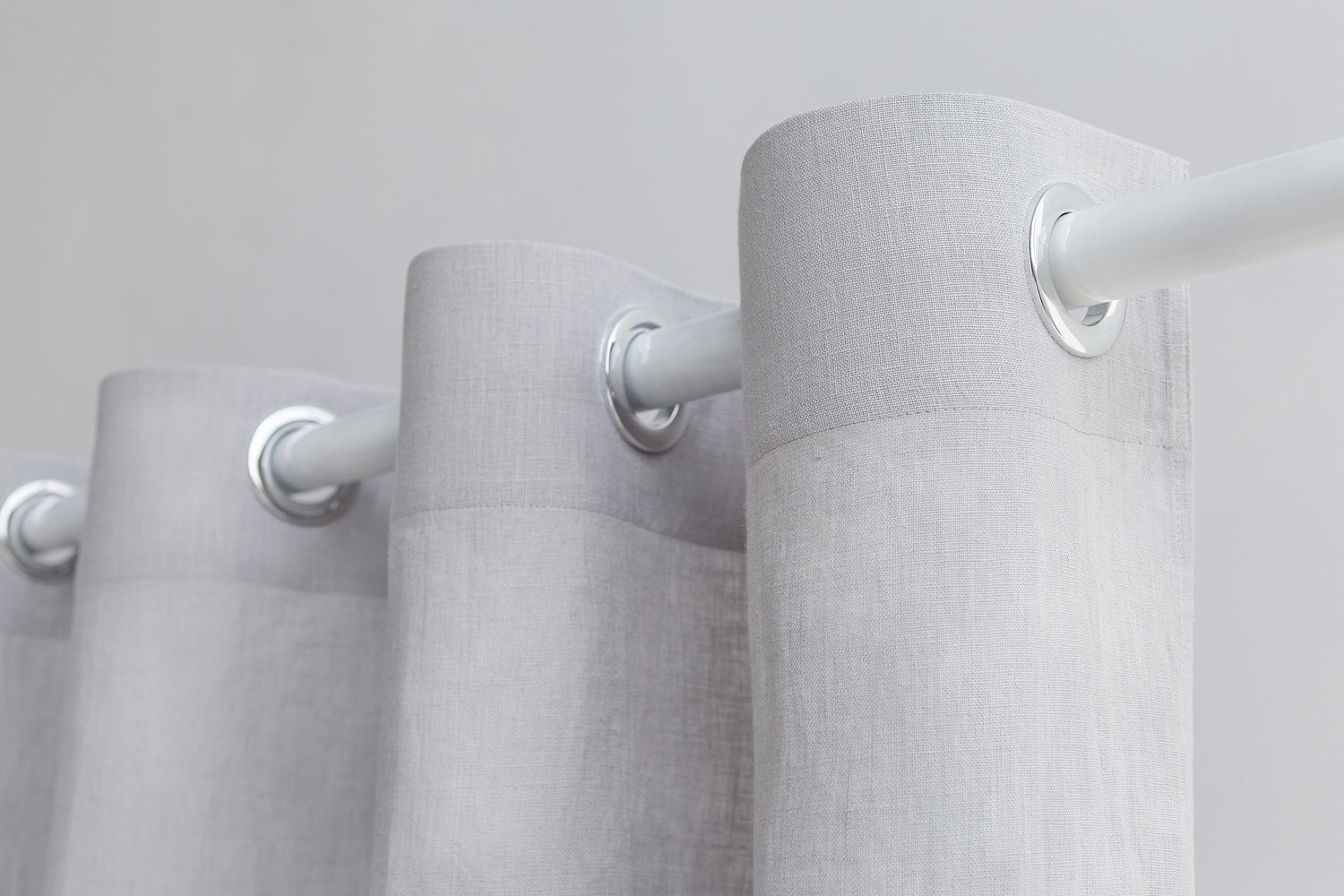Light grey linen curtain with grommets, Magenta Sugarplum home decor, hanging on a window with natural light.