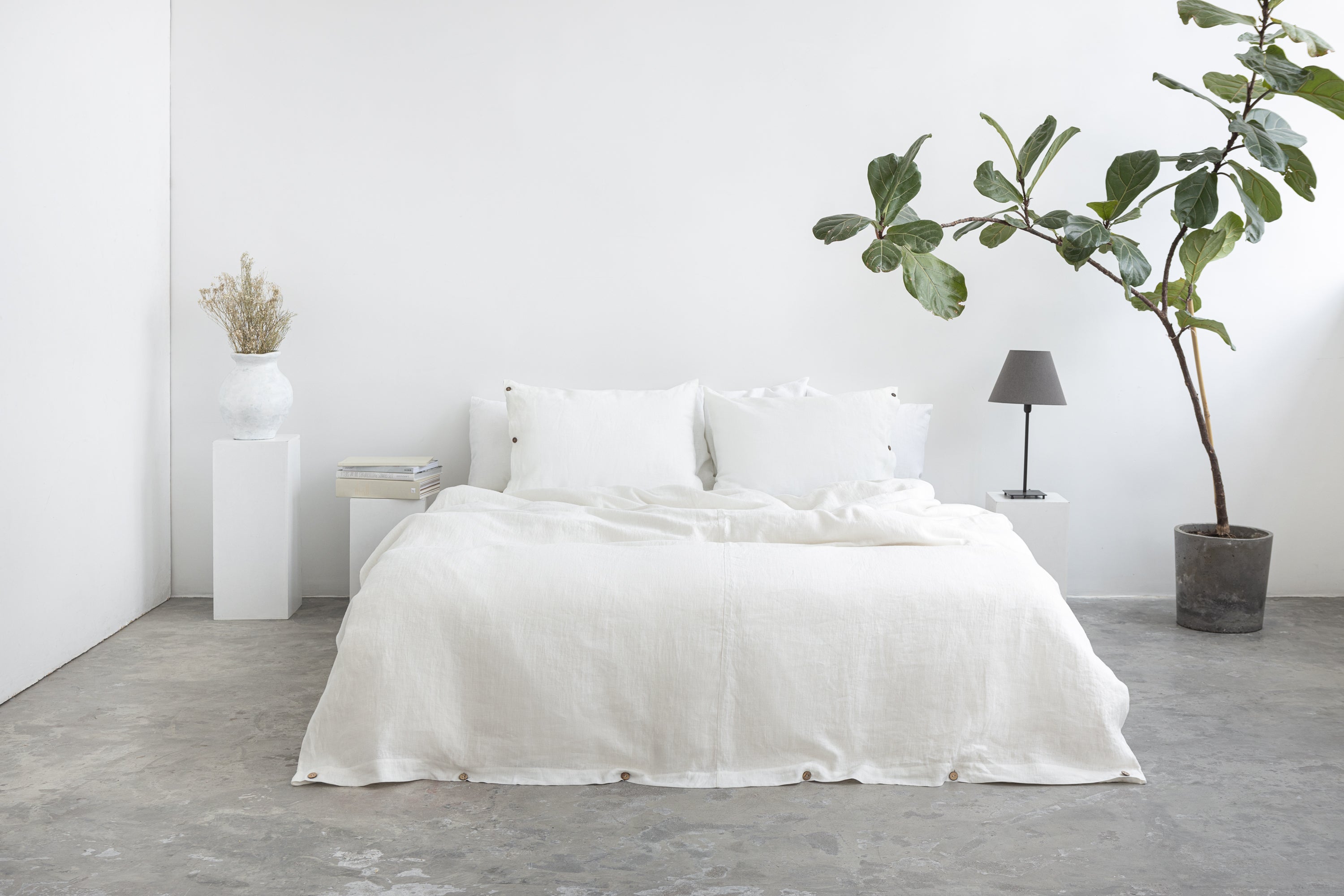 White linen bedding set with coconut button details, showcasing a cozy, elegant home decor bedroom arrangement.