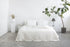 White linen bedding set with coconut button details, showcasing a cozy, elegant home decor bedroom arrangement.