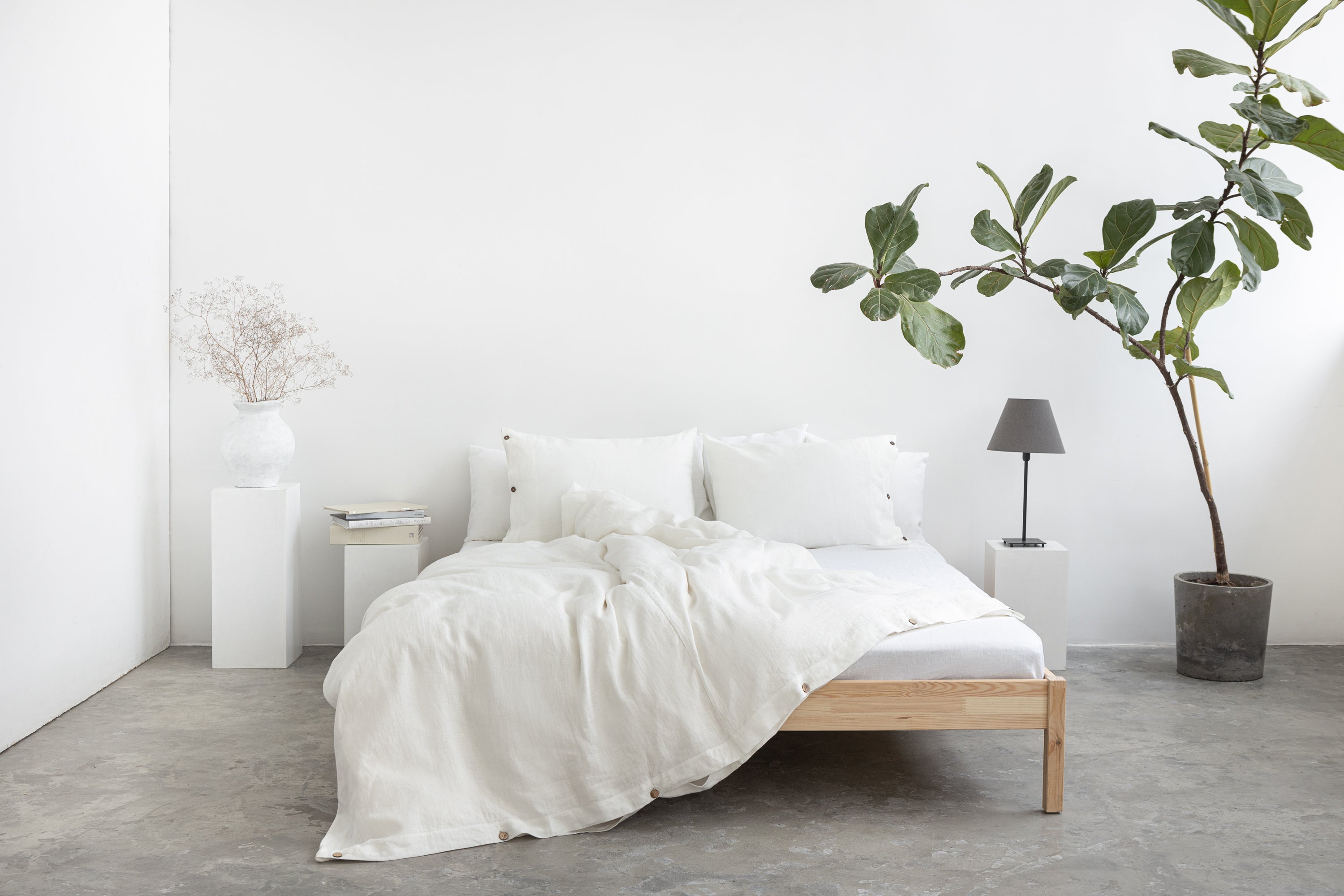 White linen bedding set with coconut button accents, featuring a cozy, elegant home decor style by Magenta Sugarplum.