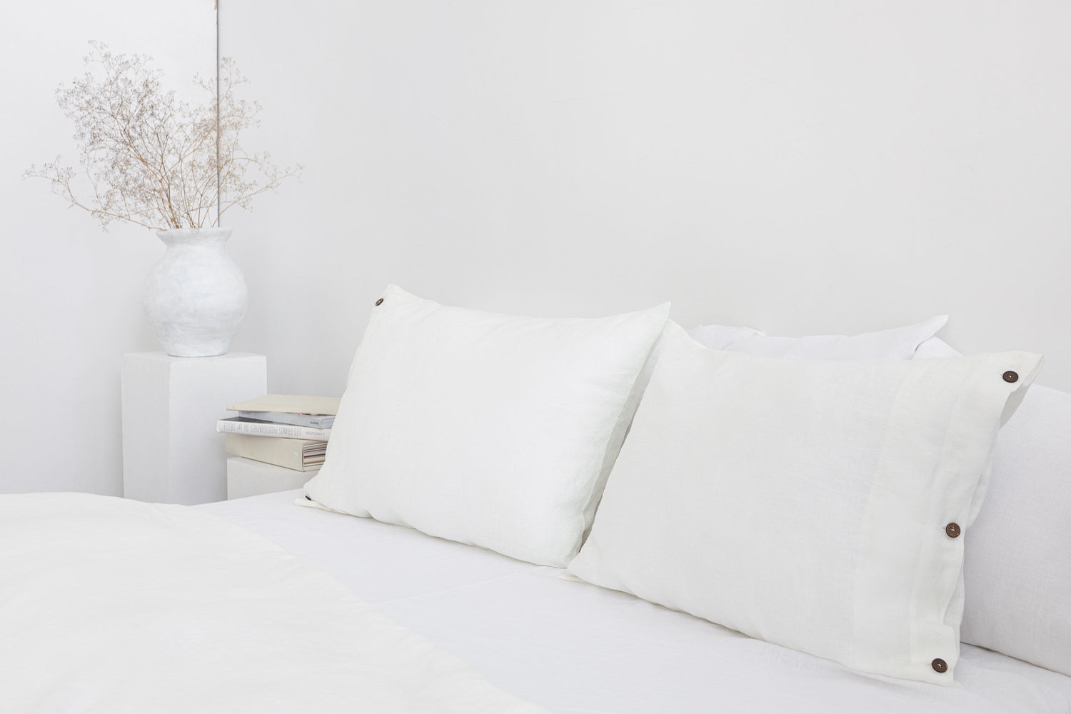 White linen bedding set with coconut button accents, featuring soft fabric and elegant design from Magenta Sugarplum.