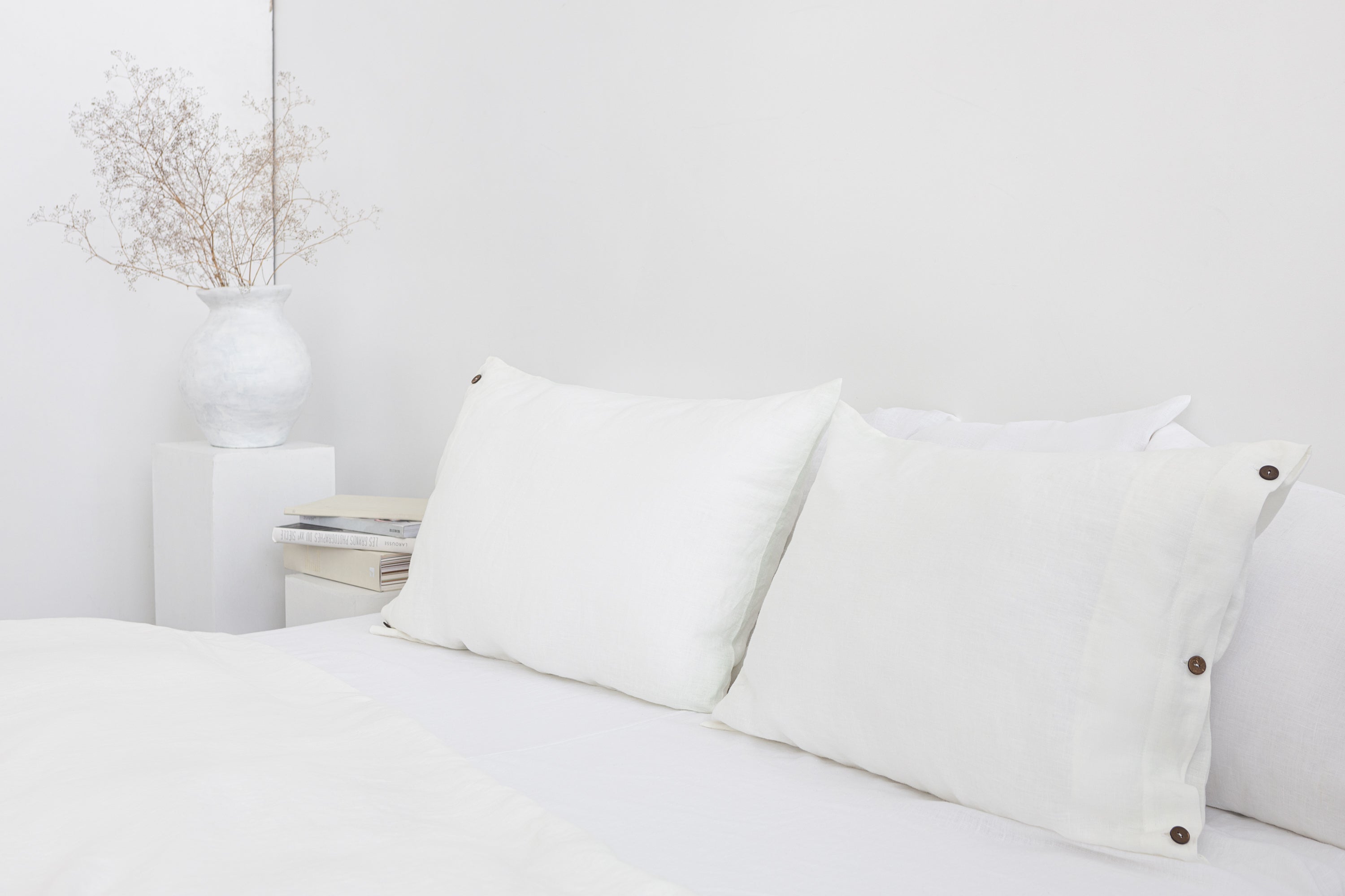 White linen bedding set with coconut button accents, featuring soft fabric and elegant design from Magenta Sugarplum.