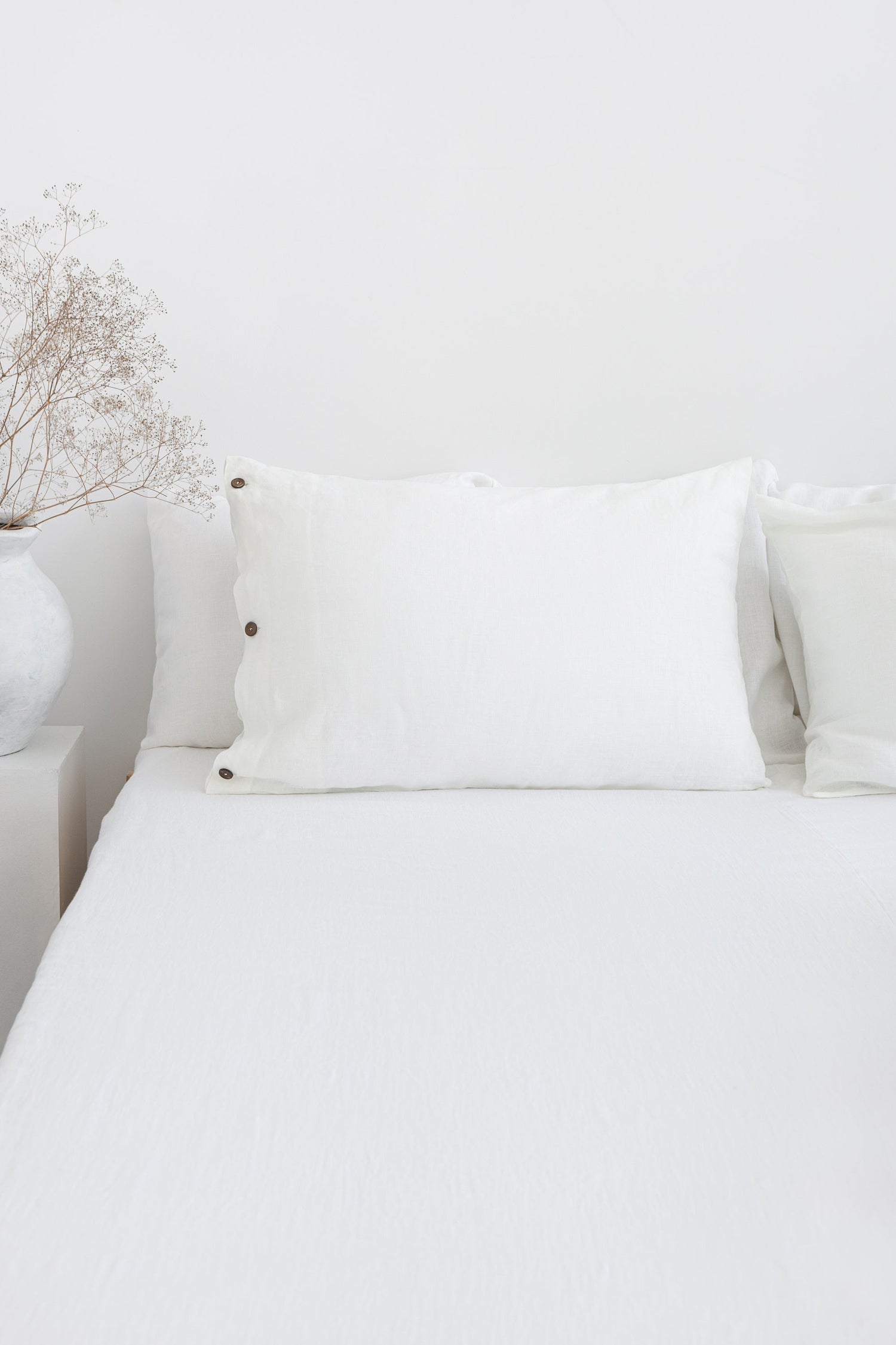 White linen bedding set with coconut button details, stylish home decor from Magenta Sugarplum.