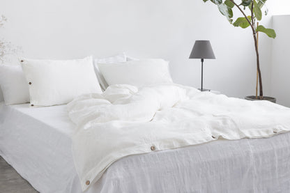 White linen bedding set with coconut button accents, showcasing a cozy, elegant home decor look by Magenta Sugarplum.