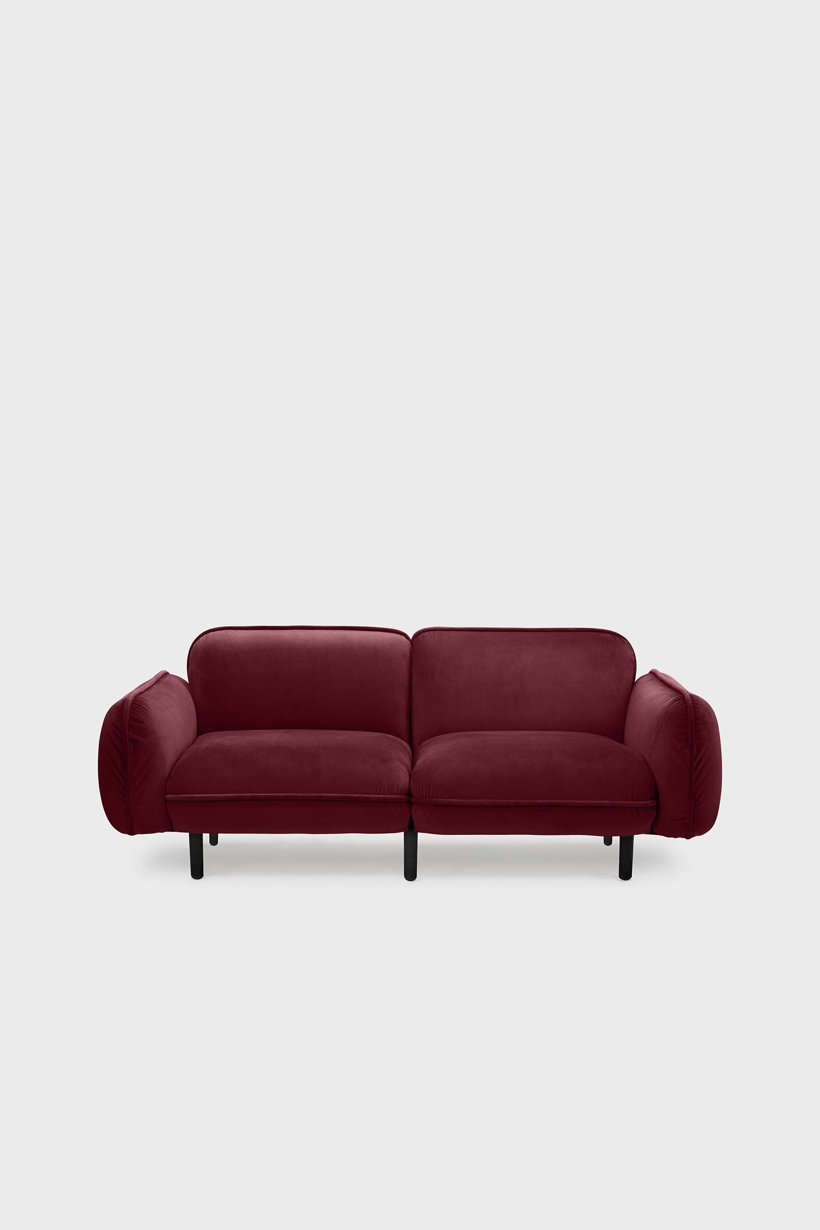 Aquamarine Poppy bean sofa with a deep red upholstery, showcasing plush cushions and modern furniture design.