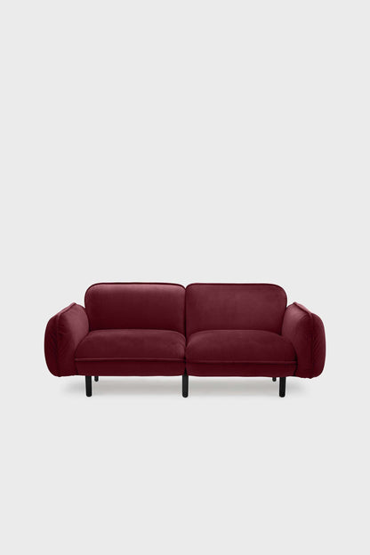 Aquamarine Poppy bean sofa with a deep red upholstery, showcasing plush cushions and modern furniture design.