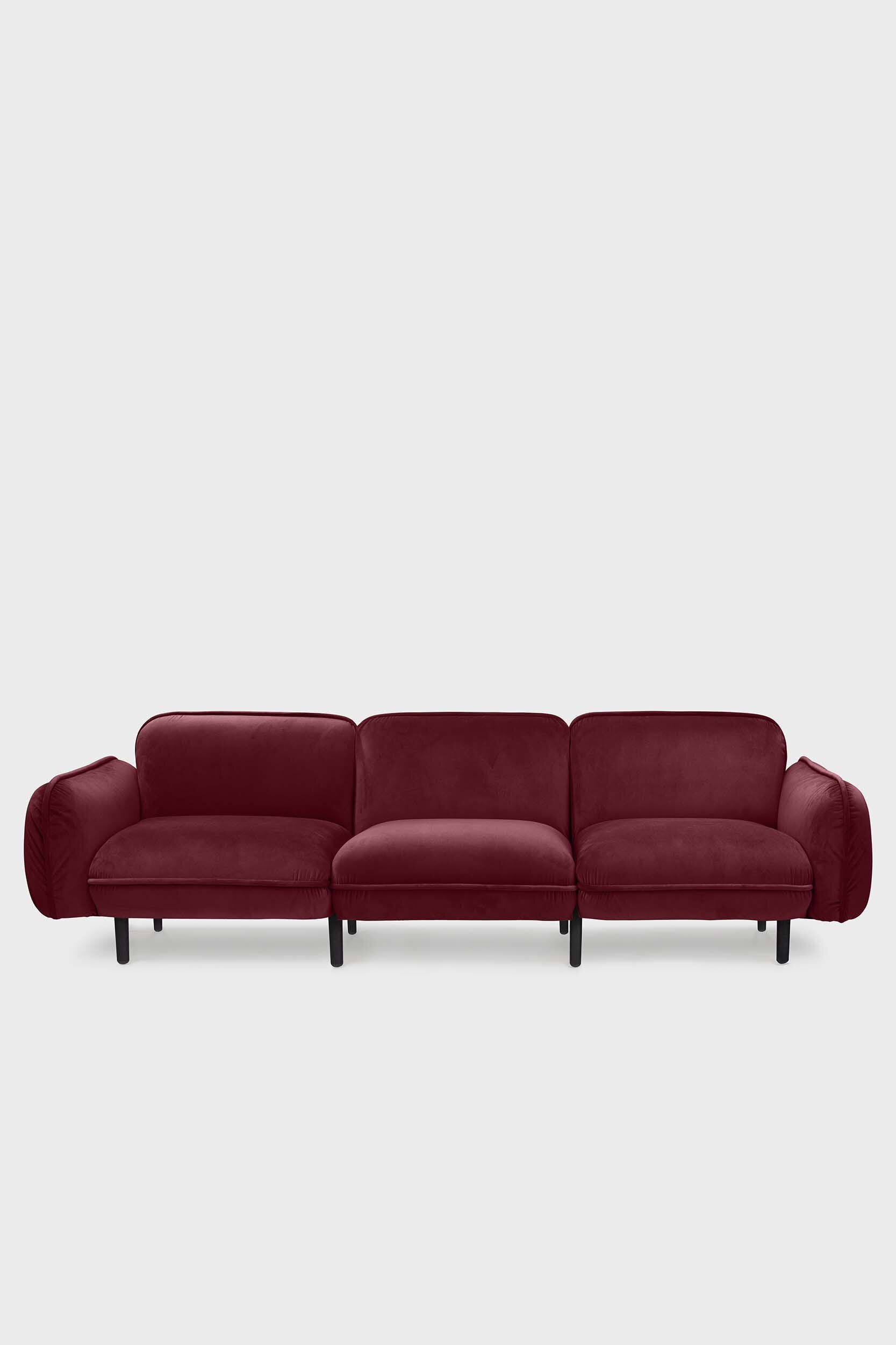 Aquamarine Poppy bean sofa with a plush, burgundy fabric and modern design, shown from a side angle in a cozy living room setting.