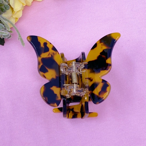 Fuchsia Hercules butterfly-shaped hair claw jewelry accessory with detailed design, secured in a natural hair style.