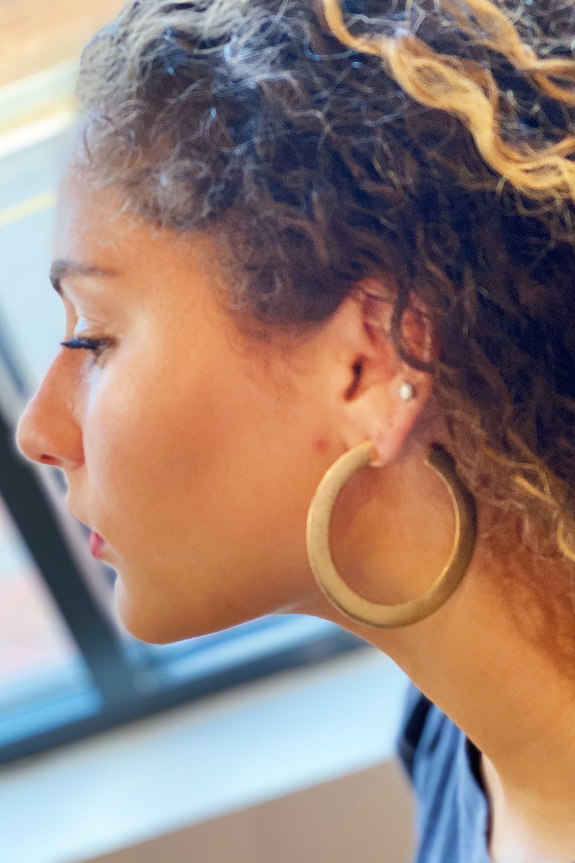 Fuchsia Hercules Alma gold metal hoop earrings, thick flattened design, stylish jewelry accessory for women.