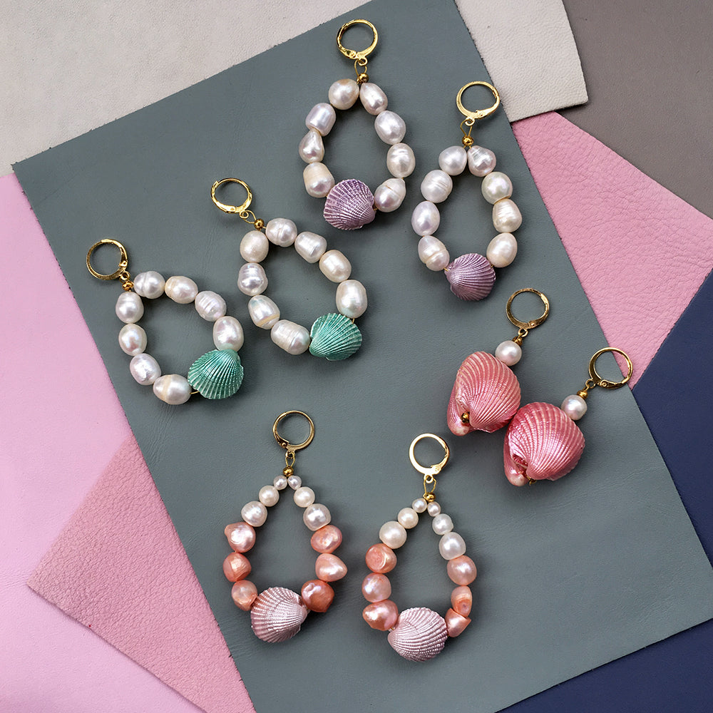 Yellow Athena Candy Shell Pearl Earrings showing glossy white pearl drop earrings with gold accents on a white background.