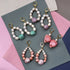Yellow Athena Candy Shell Pearl Earrings showing glossy white pearl drop earrings with gold accents on a white background.