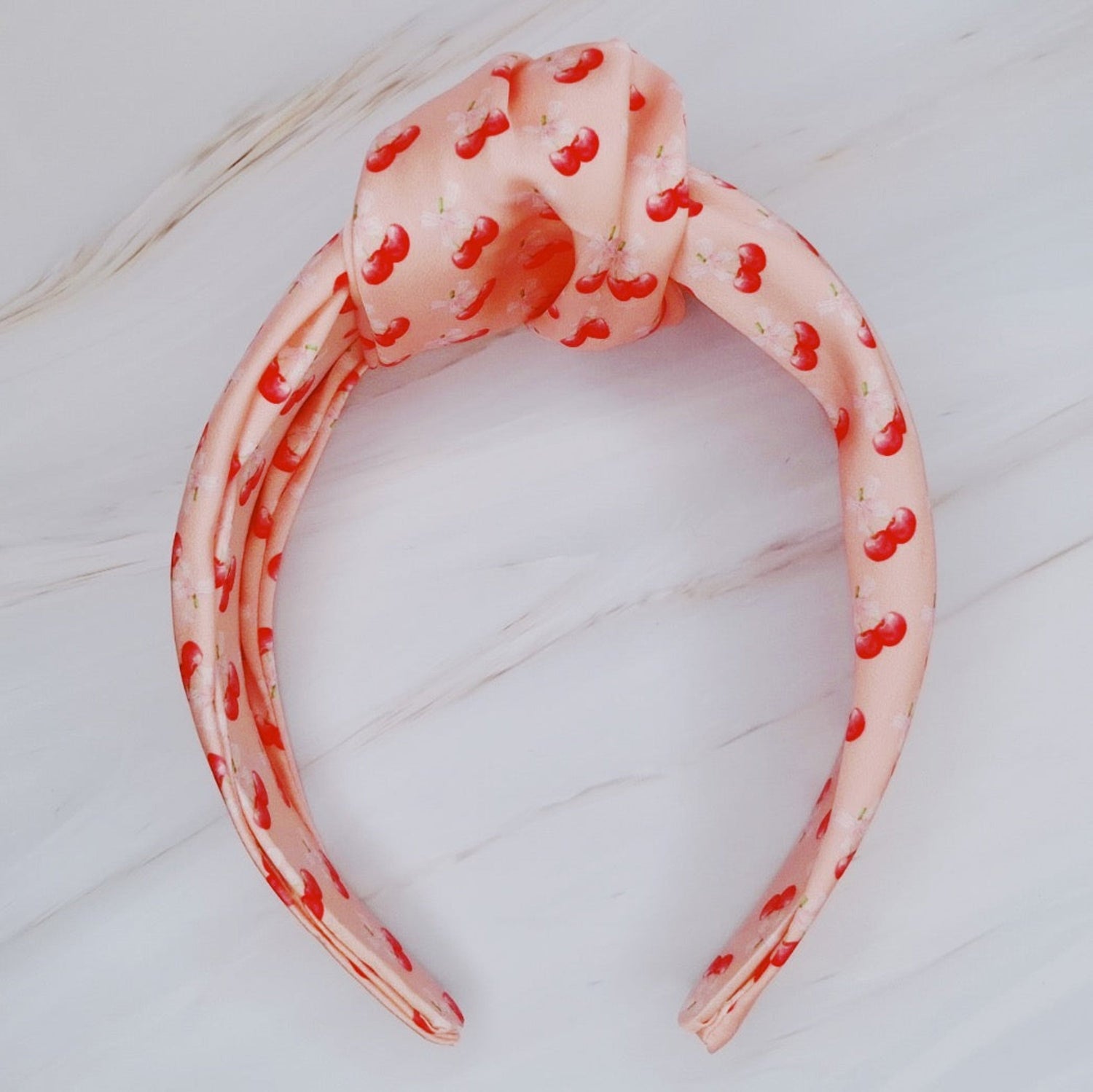 Fuchsia Hercules satin headband with cherry and bow embellishments, stylish jewelry accessory for elegant or casual wear.