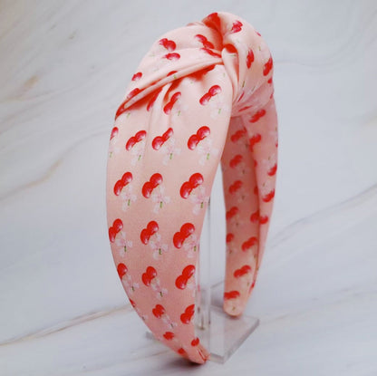 Fuchsia Hercules satin headband with cherry and bow design, featuring vibrant red cherries and elegant satin fabric.