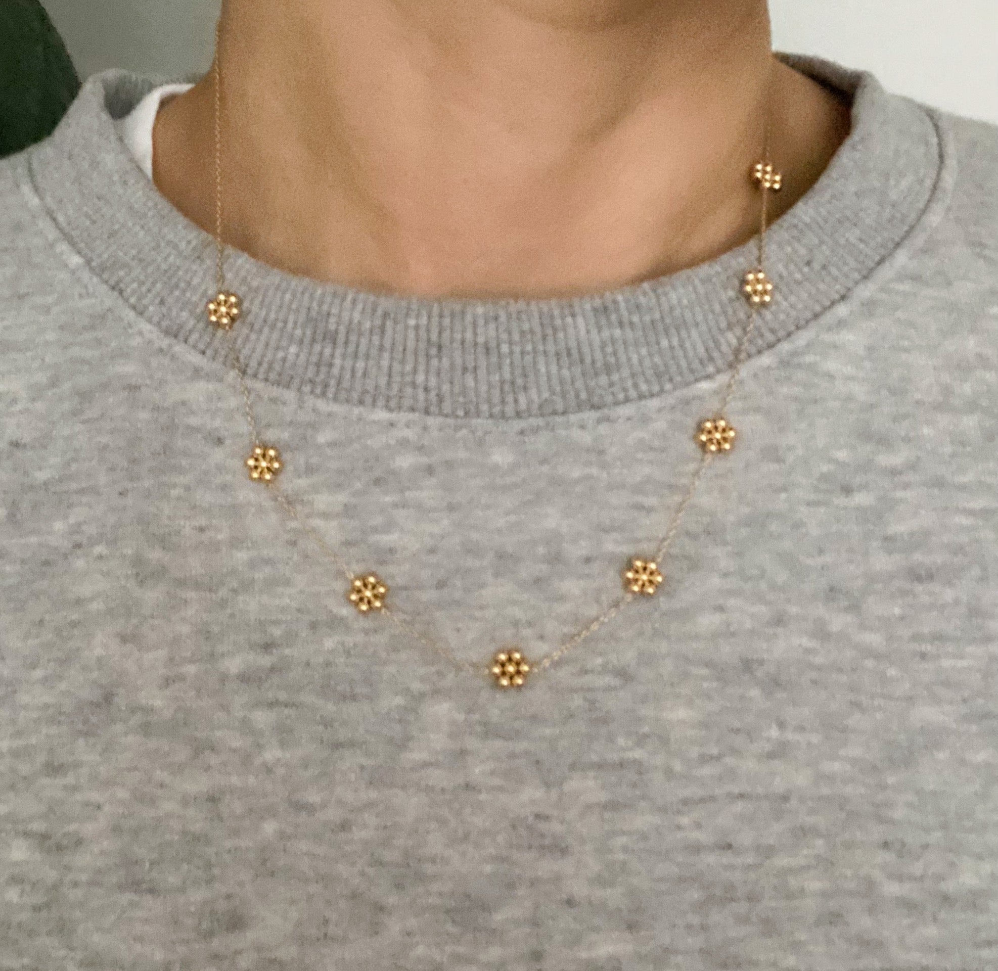 Dainty golden bead flower necklace by Fuchsia Hercules featuring waterproof stainless steel jewelry with delicate flower design.