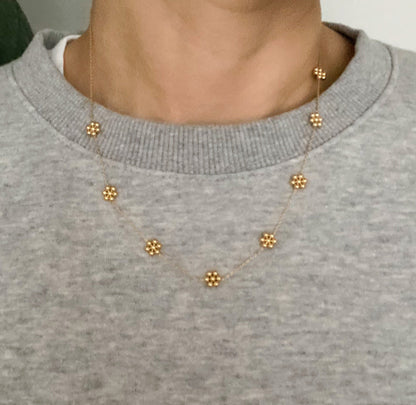 Dainty golden bead flower necklace by Fuchsia Hercules featuring waterproof stainless steel jewelry with delicate flower design.