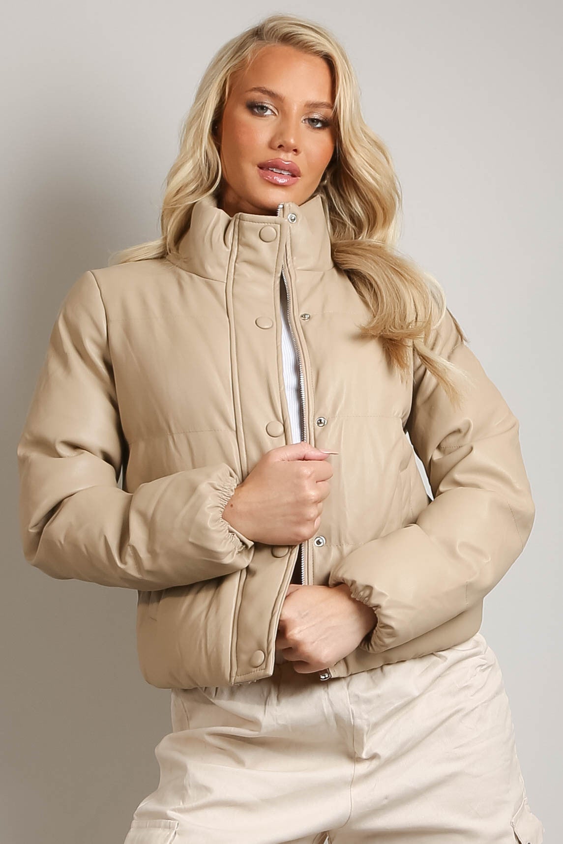 Beige PU boxy puffer jacket by Rose Eleusis displayed on a hanger, showcasing its cropped, quilted design and high collar.