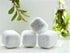 Silver Polyxena Poppy Seed bath bullets, natural and naked, displayed in a clear glass jar with fresh poppy flowers for a soothing bath experience.