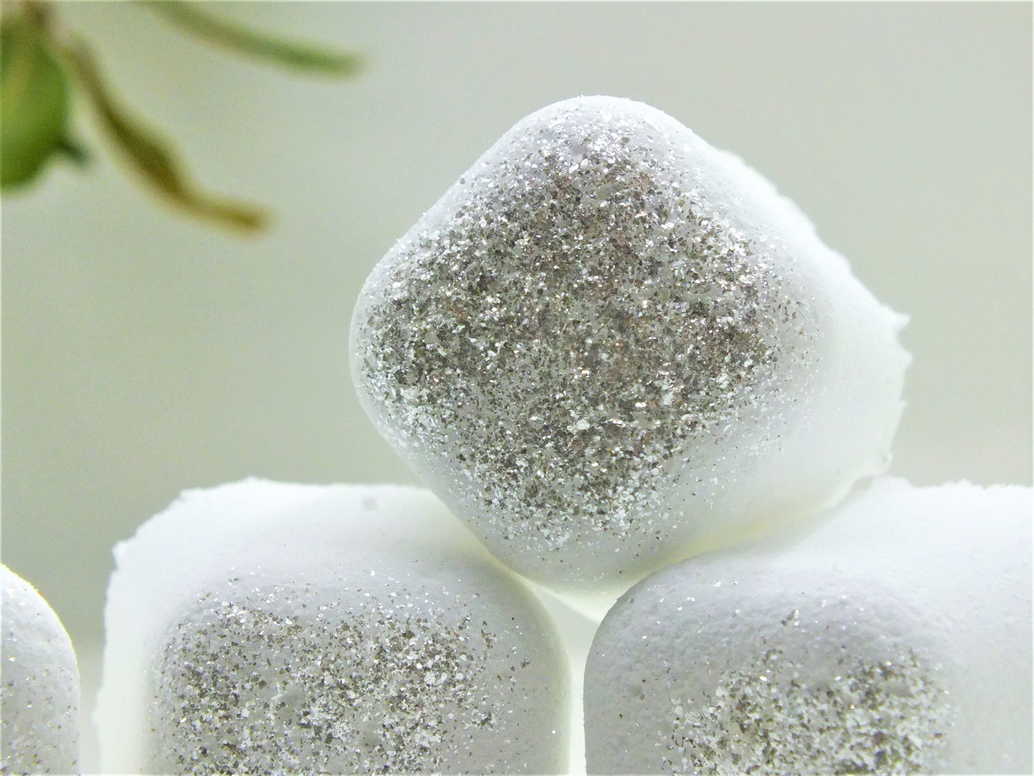 Silver Polyxena Poppy Seed bath bullets in a natural diffuser, showcasing the textured bath product with a soft, calming background.
