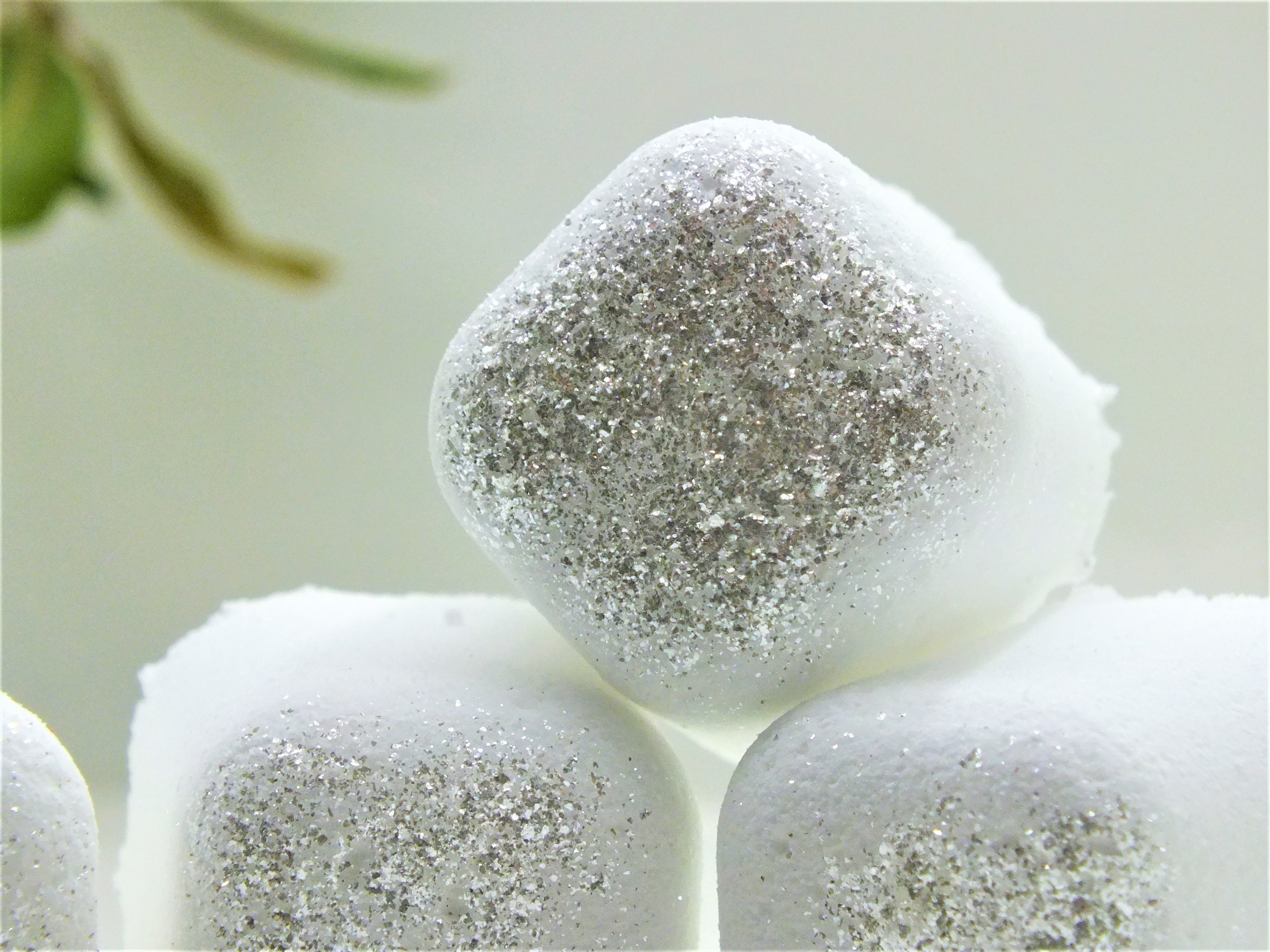 Silver Polyxena Poppy Seed bath bullets in a natural diffuser, showcasing the textured bath product with a soft, calming background.