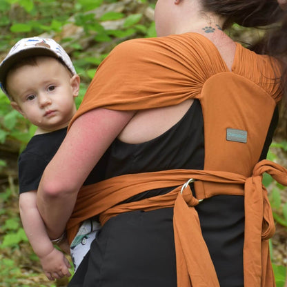 Amber Leto Snüg baby clothing in soft pastel colors, featuring a cozy onesie with playful patterns and ribbed cuffs.