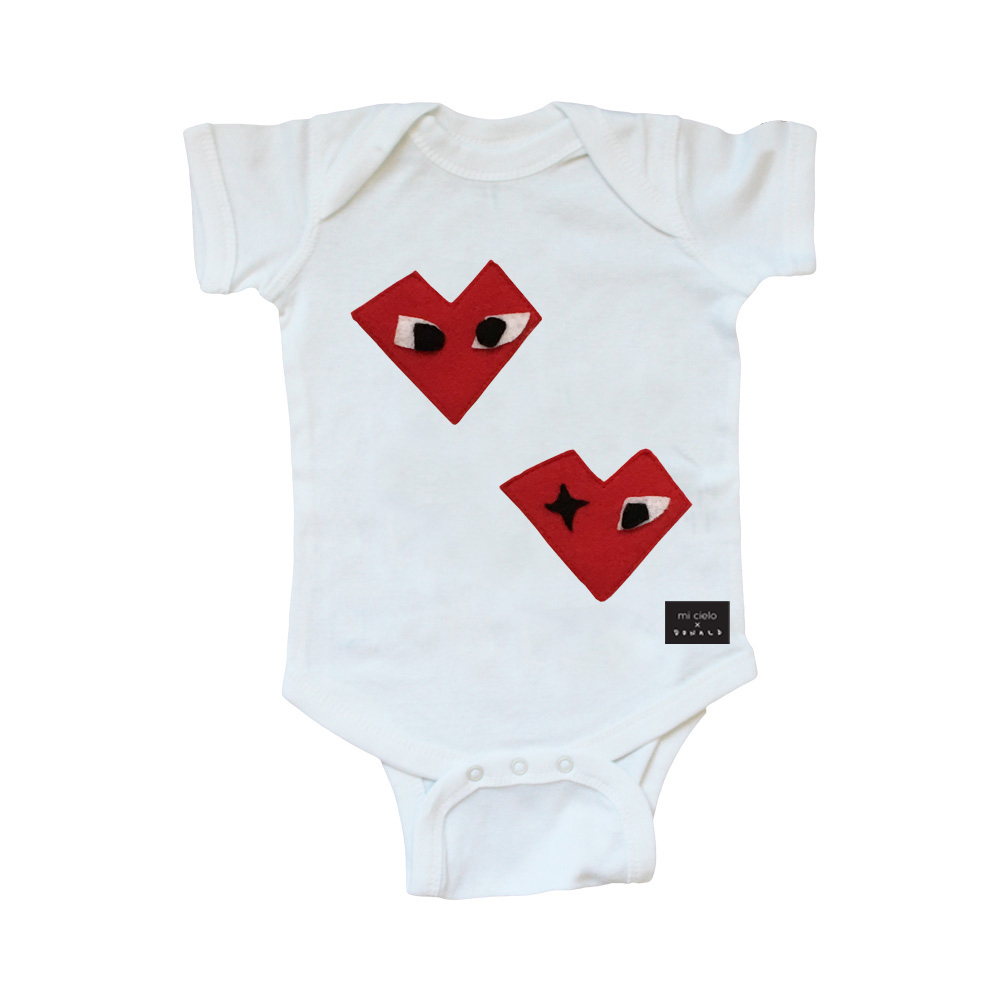 White baby onesie from Sky Blue Milo featuring a heart design by Donald Robertson, perfect for infants and young children.