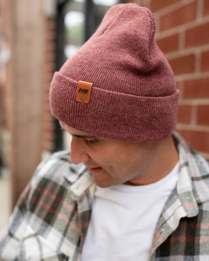 Azure Arrowwood HAAKWEAR knit cuffed beanie in rusty burgundy, featuring a cozy, textured knit design perfect for cold weather.