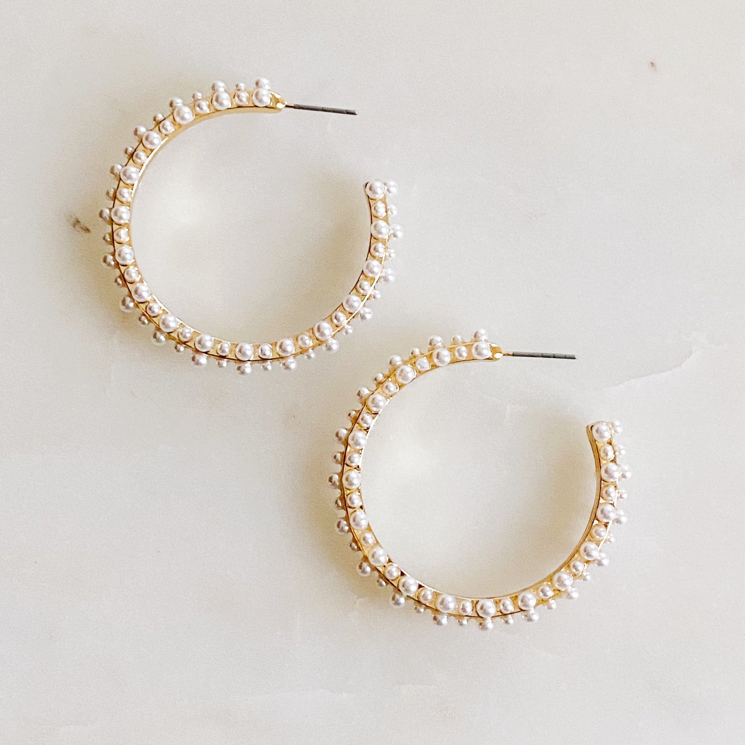 Fuchsia Hercules pearl deco hoop earrings featuring delicate white pearls on gold-tone hoops, elegant jewelry accessory.
