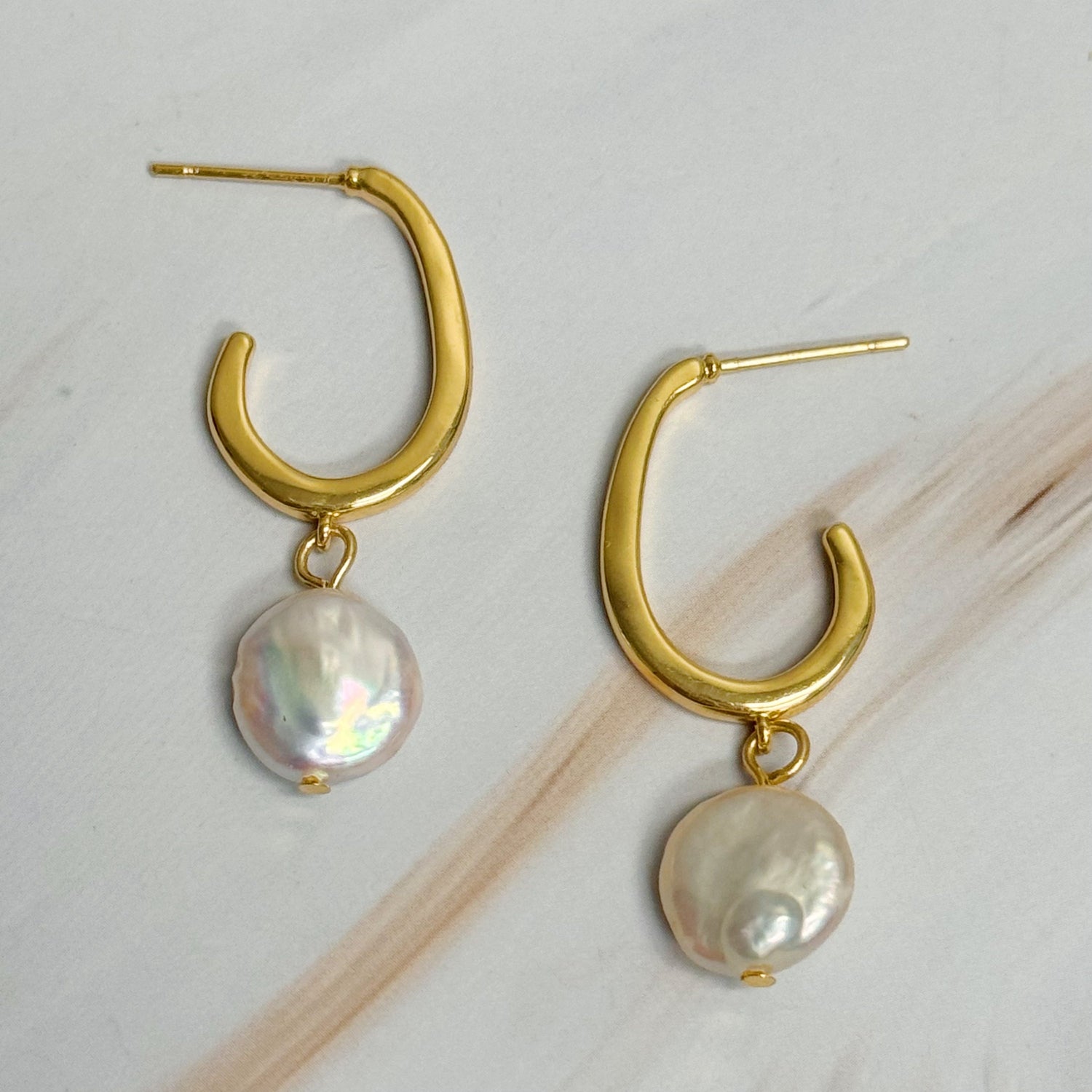 Fuchsia Hercules dangle pearl gold hoop earrings with elegant pearl accents and shiny gold hoops for jewelry and watches.