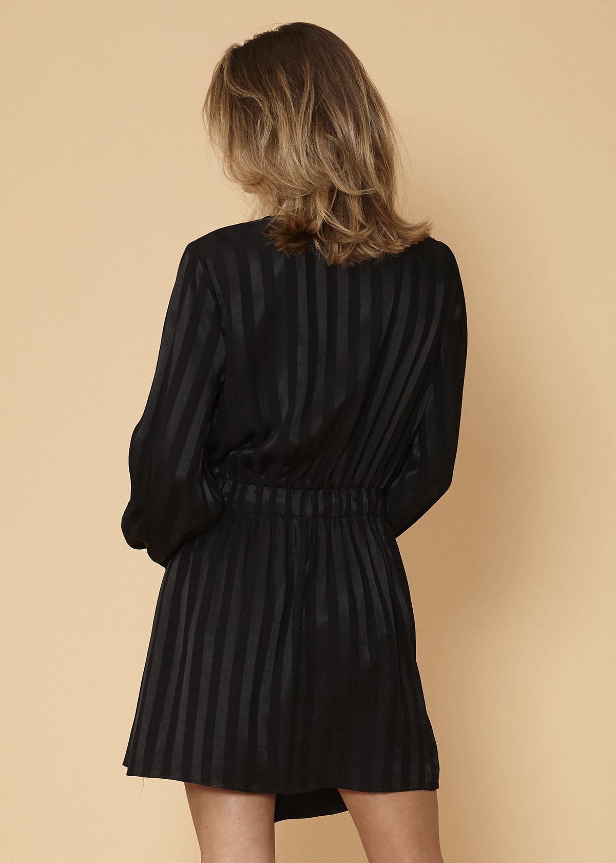 Black satin long sleeve mini dress by Lemon Hera with stripe pattern, fitted silhouette, and elegant design.