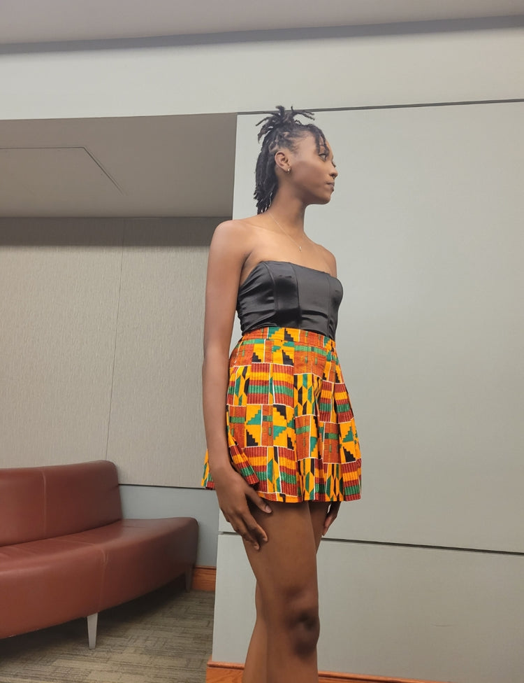 White Baobab African mini Kente skirt styled as a summer T-shirt, featuring vibrant woven fabric and casual summer wear look.