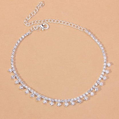 Red Iphigenia barefoot chain bracelet worn on the leg, featuring delicate jewelry design for beach accessories or gift ideas.
