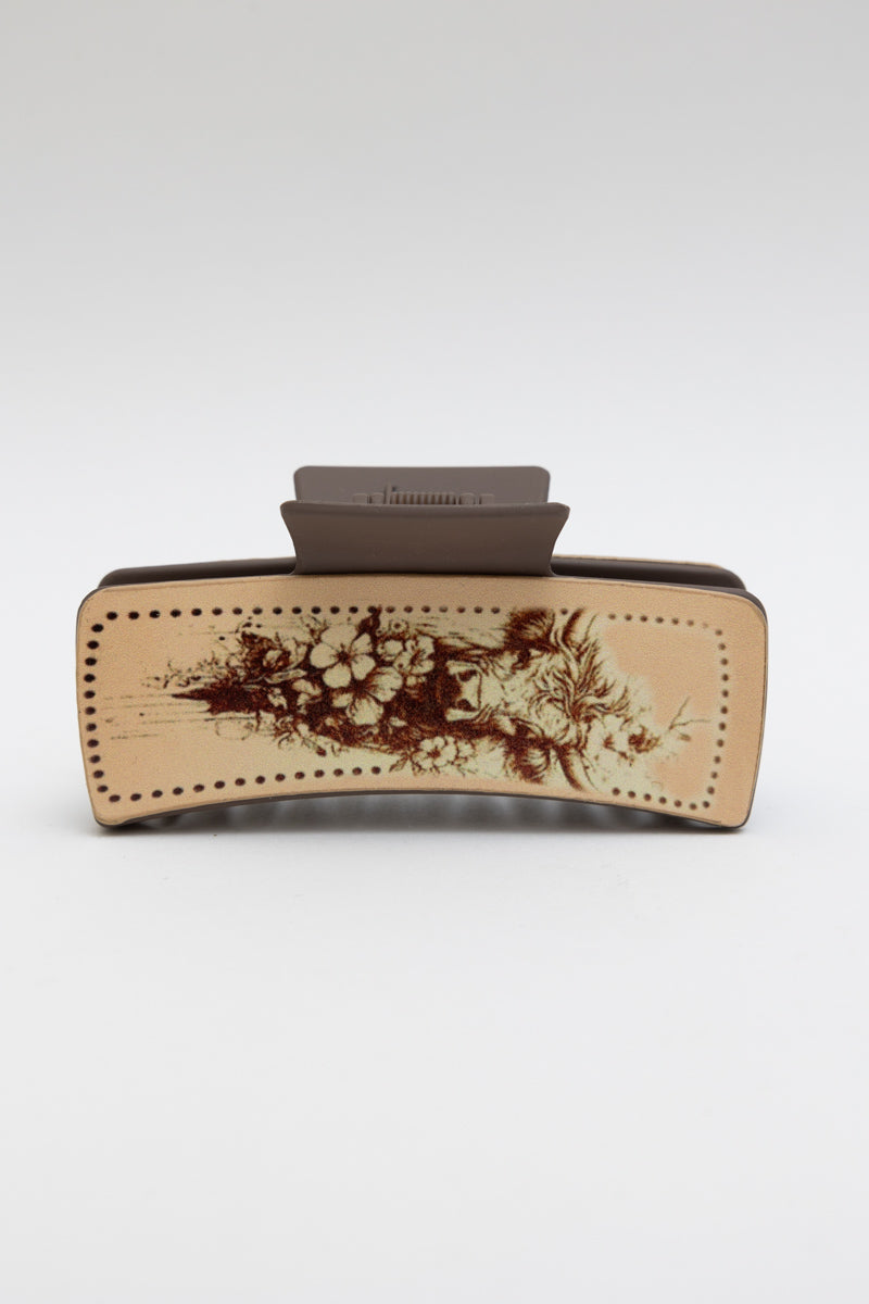 Rustic floral cow motif hair claw clip by Periwinkle Aether featuring a charming flower and cow design, perfect for accessorizing.