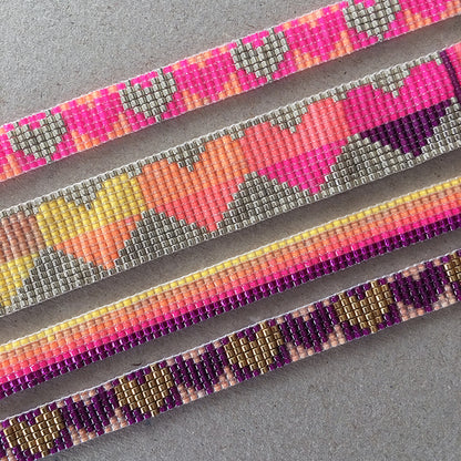 Colorful rainbow heart bracelets by Yellow Athena featuring vibrant heart-shaped charms on adjustable bands.