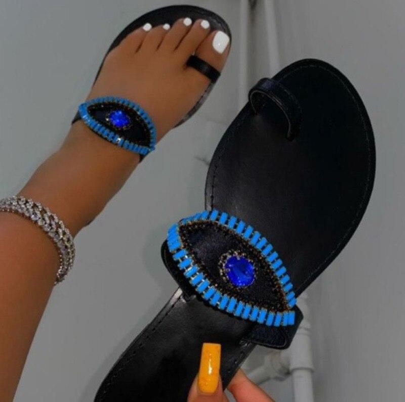 Female Rhinestone Eyes Slides by Coffee Jasper featuring round toe flat slippers with sparkling rhinestone eye embellishments.