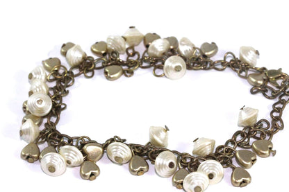 Silver Hestia golden hearts and shells charm bracelet featuring delicate charms on a sleek silver chain.