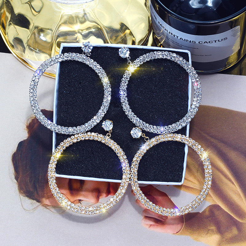 Shiny diamond hoop earrings from Blush Bella, showcasing elegant jewelry design with sparkling diamonds in a classic hoop style.