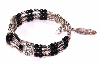 Silver Hestia feather charm and beads bracelet with delicate silver charms and colorful beads on a black background.