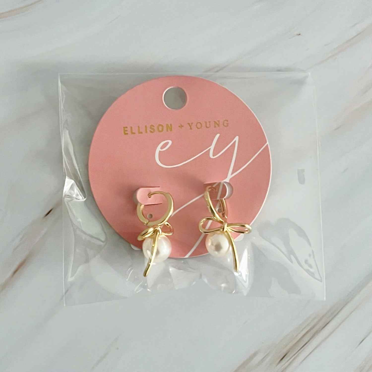 Fuchsia Hercules bowed pearl drop earrings featuring elegant jewelry design with lustrous pearl accents on a delicate metal setting.