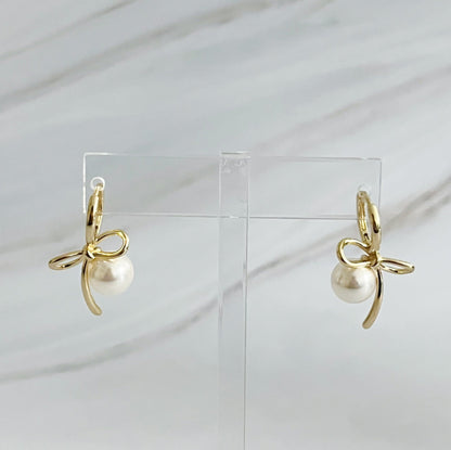 Fuchsia Hercules bowed pearl drop earrings featuring elegant jewelry design with hanging pearl accents.