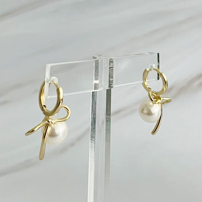 Fuchsia Hercules bowed pearl drop earrings featuring elegant teardrop-shaped pearls and a delicate jewelry design.