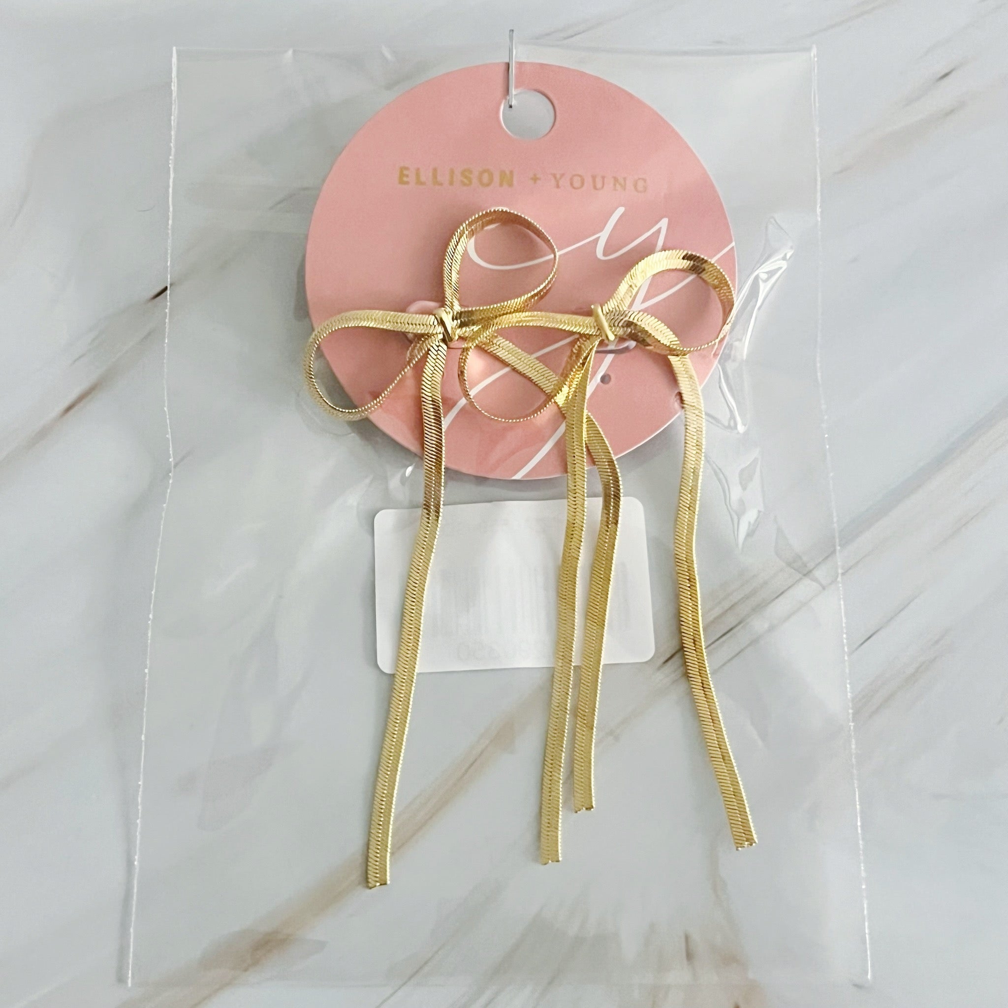 Fuchsia Hercules long drop bow earrings featuring elegant jewelry design with gold-tone finish and delicate bow details.