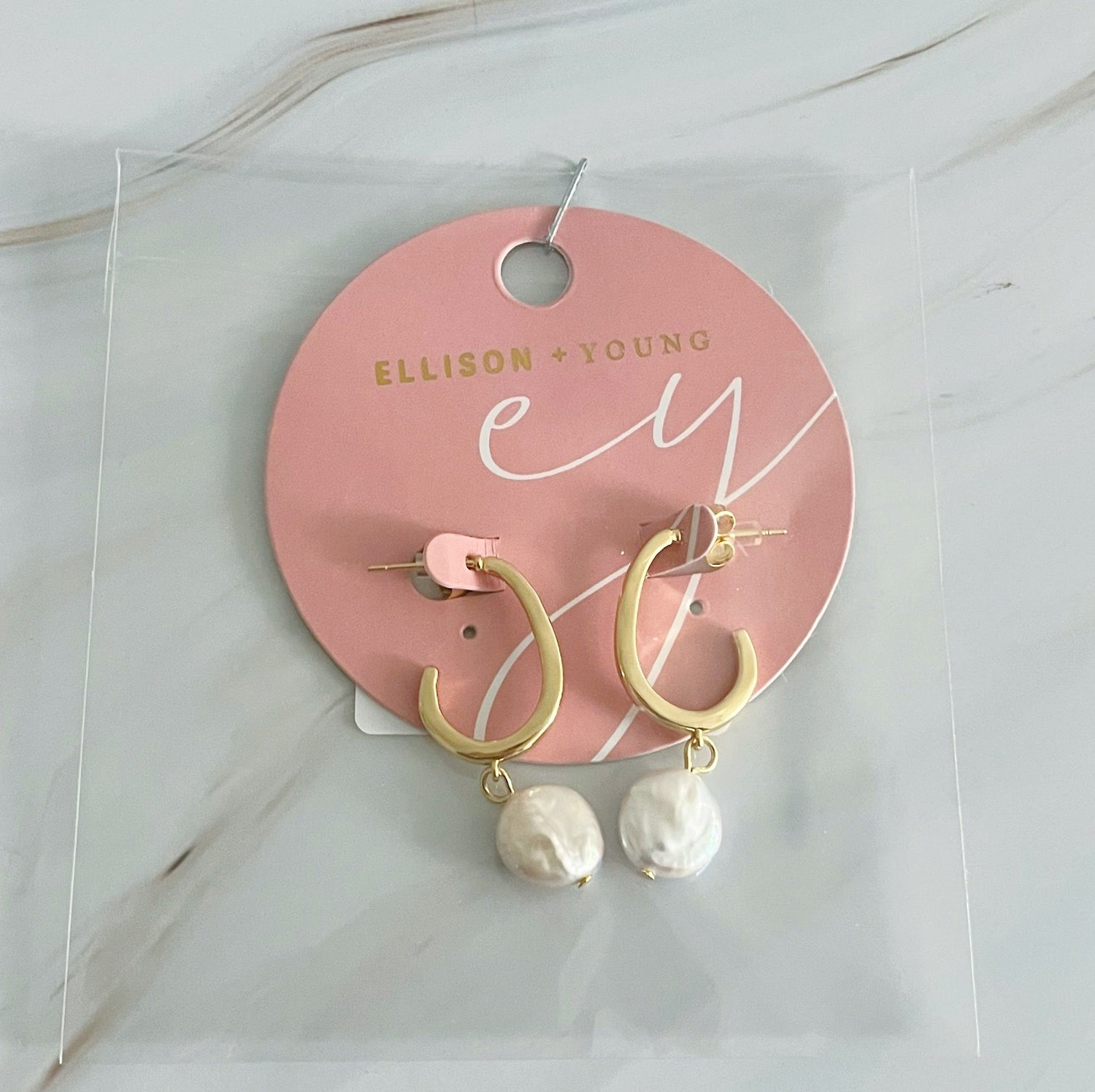 Gold hoop earrings with dangling pearls by Fuchsia Hercules, showcasing elegant jewelry design and intricate craftsmanship.