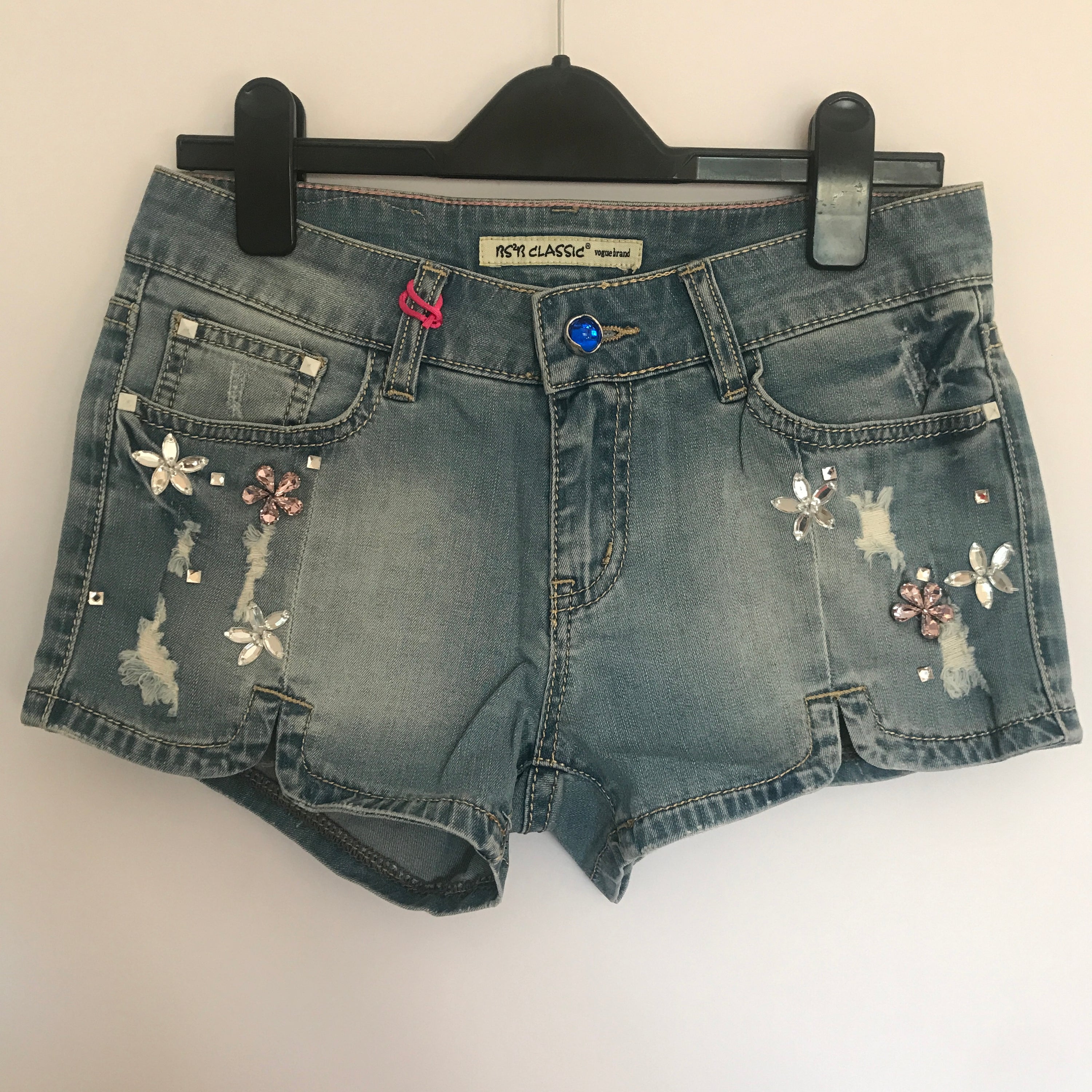 Flower rhinestone denim shorts by Blush Bella featuring sparkling flower embellishments on classic blue denim.