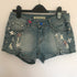 Flower rhinestone denim shorts by Blush Bella featuring sparkling flower embellishments on classic blue denim.