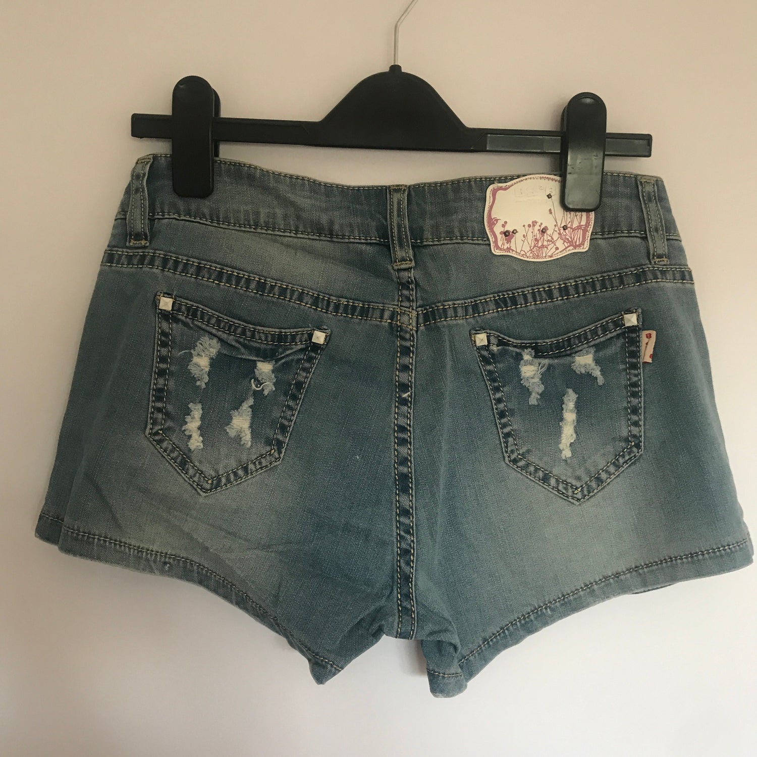 Flower rhinestones denim shorts by Blush Bella featuring decorative floral rhinestone embellishments on casual denim.