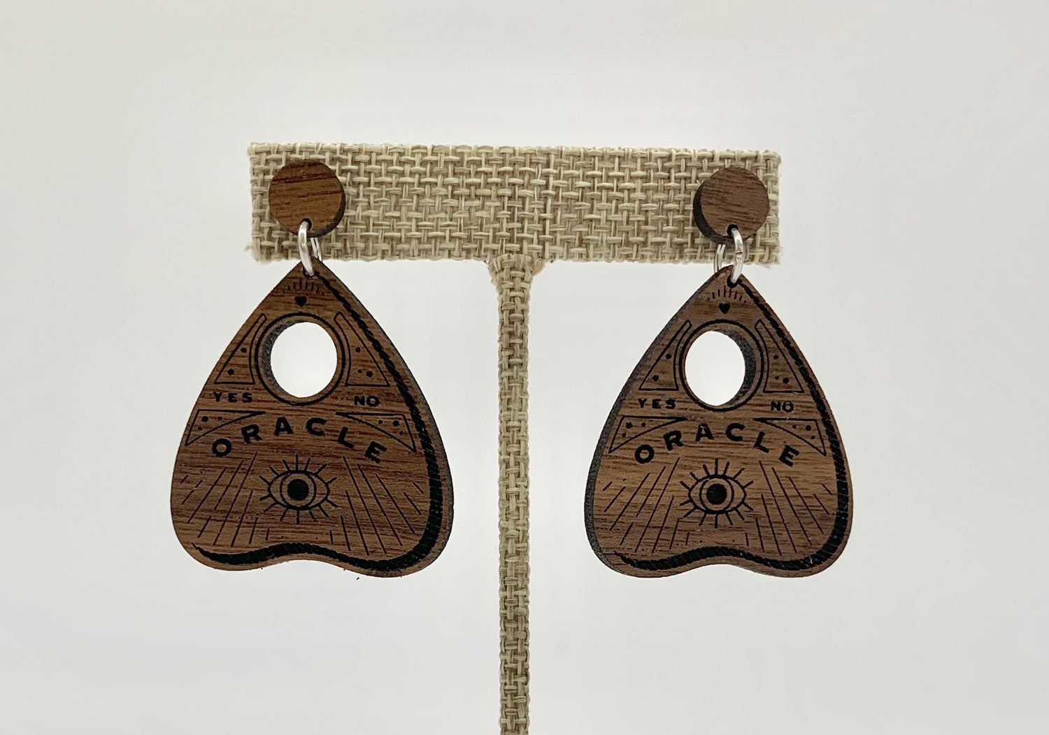 Yellow Coconut Ouija earrings with black and white design, hanging from silver hooks, showcasing spooky occult-themed accessories.