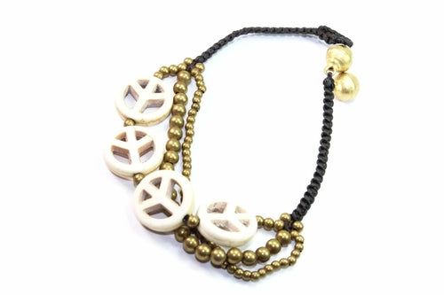 Silver Hestia boho peace symbol bracelet with engraved charm and beaded design, laid out on a neutral background.