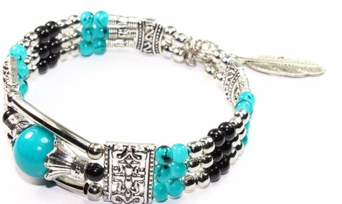 Silver Hestia feather charm bracelet with beads, featuring delicate metal feather and bead details on a stylish bracelet.