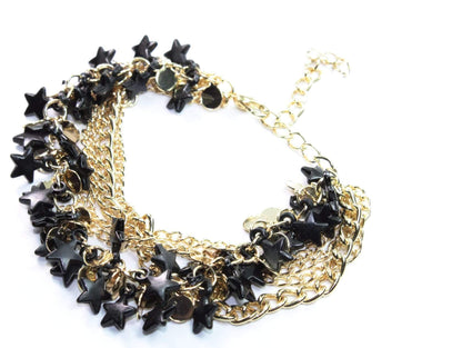 Silver Hestia three-tier star charm bracelet with layered silver chains and star pendants on a neutral background.