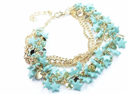 Silver Hestia three-tier star charm bracelet with layered silver chains and star-shaped charms on a neutral background.
